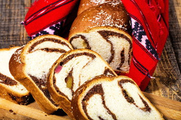 Slices of Romanian sponge cake with red traditional towel