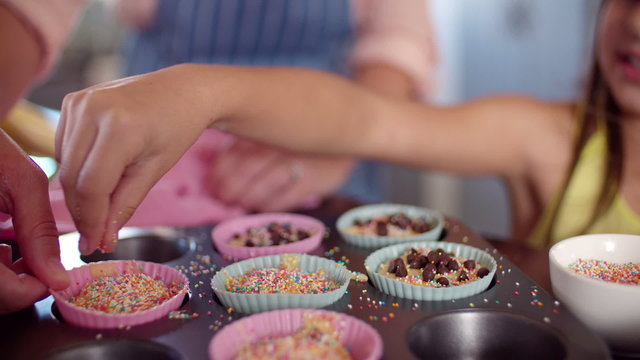 Mom and daughter decorating cupcakes together