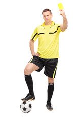 Young football referee showing a yellow card