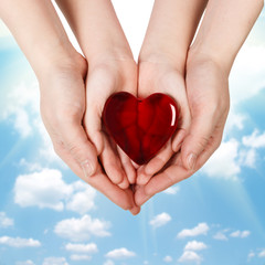 Fototapeta premium Family concept - mother's hands holding child hands with heart