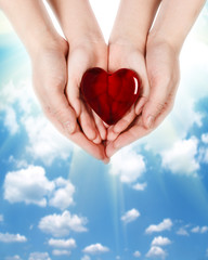 Obraz premium Family concept - mother's hands holding child hands with heart