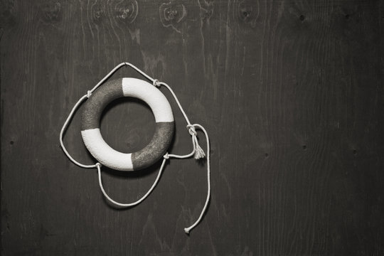 black and white life buoy hanging on the side of a wood