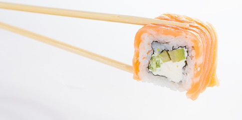 Sushi roll with chopsticks isolated on white