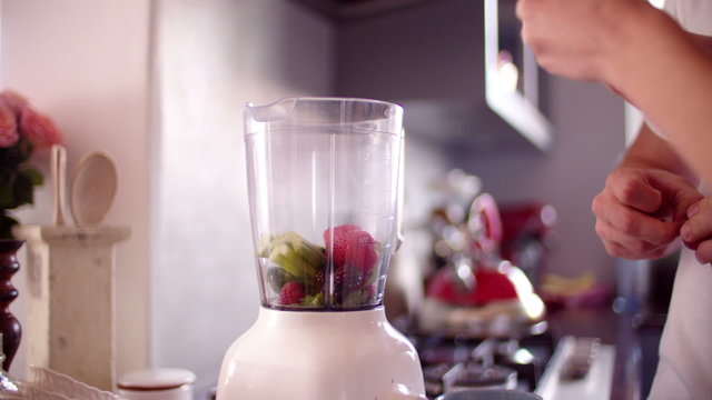 couple using blender to make fresh smoothie for breakfast