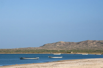 Fototapeta na wymiar Barcas de madera vacías en el idílico paisaje de una playa caribeña en el Cabo de la Vela en la región de la Guajira en Colombia