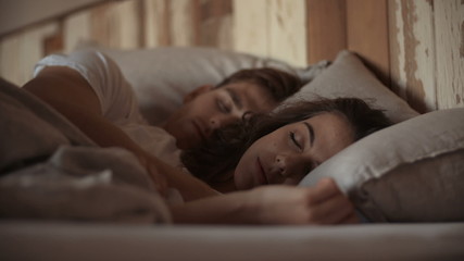 Young sleeping couple in bed - Powered by Adobe