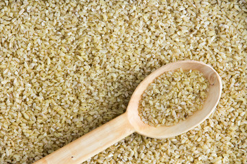 Cracked wheat background texture with angled spoon