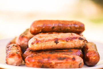 Barbecued beef and pork sausages on white plate