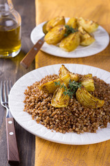 Buckwheat porridge with baked onions on a wooden table