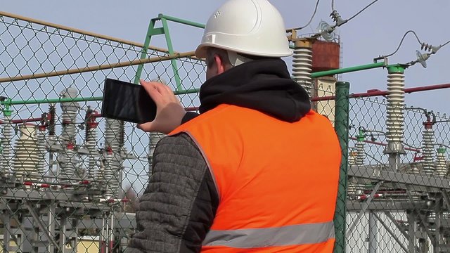 Electrical engineer filmed with tablet PC at power plant