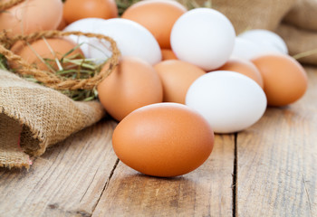 table decoration with easter eggs nest on plate, on white wooden