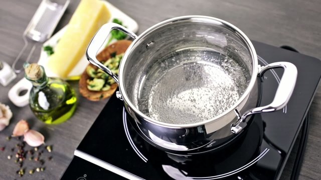 Cooking organic pasta with garlic herbs and parmesan cheese.