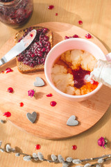 Obraz na płótnie Canvas tea with pouring milk, homemade bread with blackcurrant jam