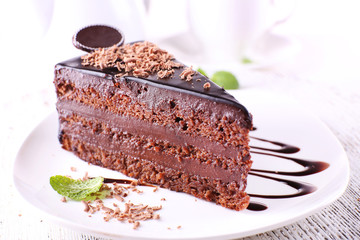 Delicious chocolate cake on plate on table on light background
