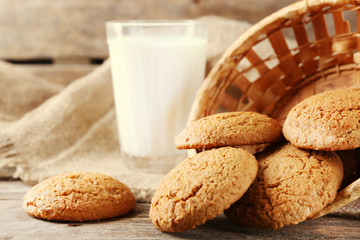 Tasty cookies and glass of milk on rustic wooden background