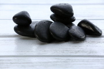 Spa stones with water drops on wooden background