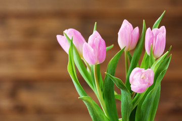 Beautiful pink tulips on wooden background