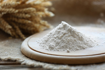 Pile of flour on cutting board with burlap cloth, closeup