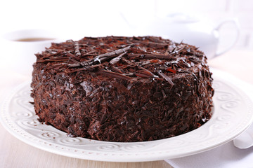 Tasty chocolate cake with cup of tea on table close up
