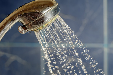 Shower head working on blue background