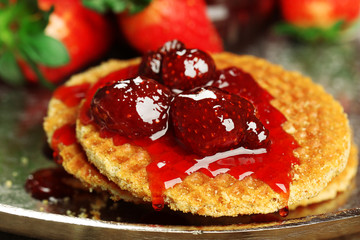 Wafers with strawberry jam and berries on tray close up