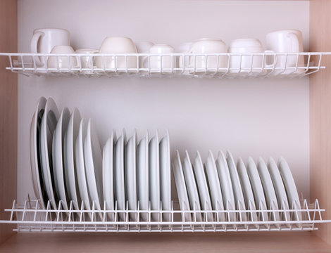 Clean Dishes Drying On Metal Dish Rack On Shelf