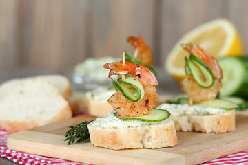 Appetizer canape with shrimp and cucumber on table close up