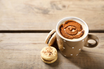 Cup of coffee  and macaroons on old wooden table