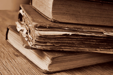 old books on a rustic wooden table, sepia toning