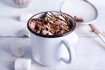 Mug of cocoa with marshmallows on wooden background