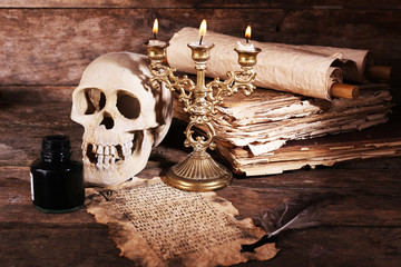 Still life with human skull, retro book and quill
