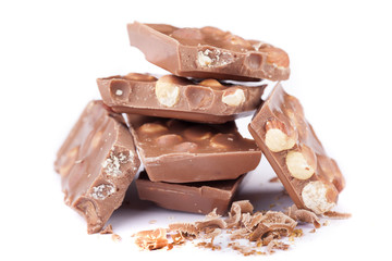 Milk chocolate with hazelnuts on white background