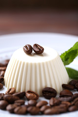 Tasty panna cotta dessert on plate, close up
