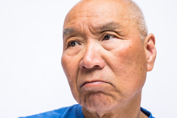 怒り顔のシニアのアップ