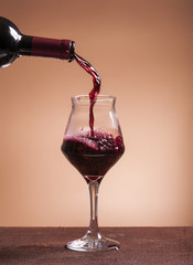 Red wine bottle pouring wineglass closeup