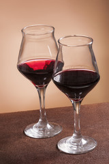 Two filled wineglasses on brown background