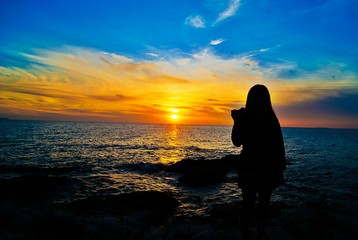 Fototapeta premium Girl take a photo sunset