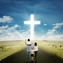 Parents and kids on the road with a cross © Creativa Images