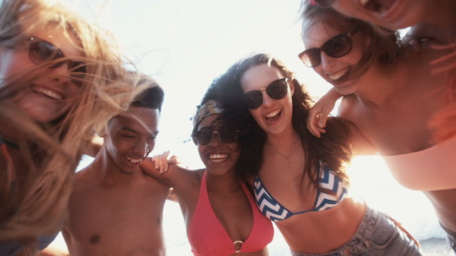 Mixed race group of friends standing together on a beach