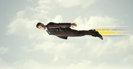 Happy business man flying fast on the sky between clouds
