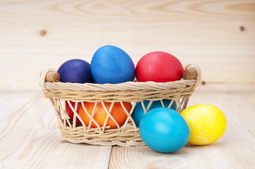 Easter eggs in basket on wooden background