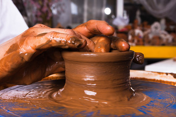 hands working on pottery wheel, closeup