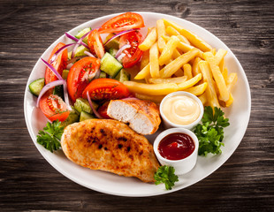 Fried chicken fillet, chips and vegetable salad