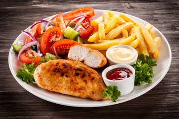 Fried chicken fillet, chips and vegetable salad