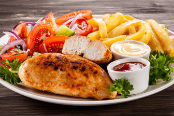 Fried chicken fillet, chips and vegetable salad