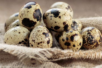 Many quail eggs on jute background