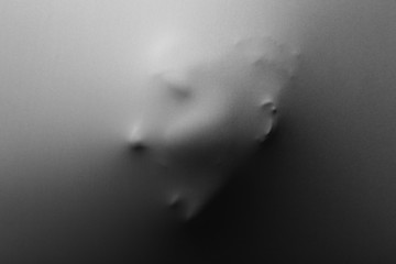 Obraz premium Screaming human face pressing through fabric as horror background