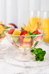 Fruit salad with mint and orange juice in glassware
