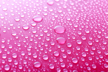 Water drops on glass on pink background