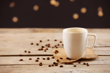 Cup of coffee on table on brown background